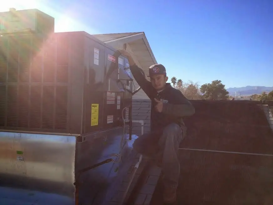 HVAC technician performing AC Tune-Up on a rooftop unit in Des Moines